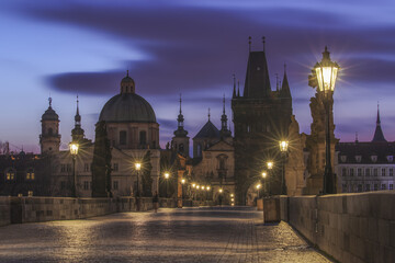 View of the iconic Charles Bridge is bathed in the soft glow of dawn, its ancient stones reflecting the light amidst the towering spires, Prague, Prague, Czechia.