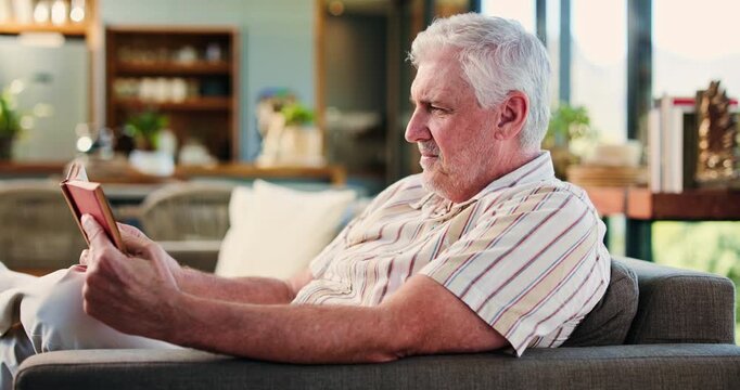 Living room, relax and senior man reading book in home, literature novel and language learning on weekend. Knowledge, fiction story or elderly person with reference guide for education, info and rest