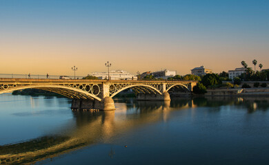 The historic Triana Bridge over the Guadalquivir River in one of the historic districts of the beautiful Andalusian city