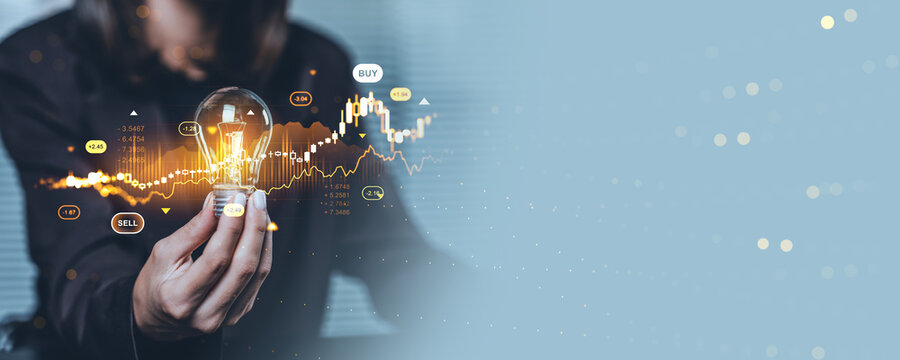 Businesswoman holding lightbulb with forex and stock market chart hologram on blue background representing investment and future financial growth concept. - Powered by Adobe