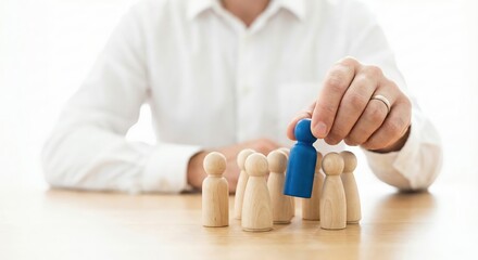 Professional White Adult Man in Office Selecting Blue Wooden Figure from Crowd for Recruitment Concept, Human Resources and Talent Acquisition Strategy Indoors in Bright High-Key Lighting