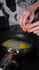  man cooking scrambled eggs for breakfast early in the morning