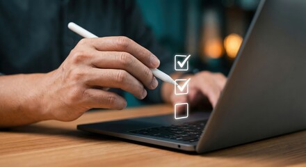 An adult South Asian man in a blue shirt indoors at a wooden desk using a stylus to complete a digital checklist on a laptop, concept of productivity and task management, morning light.