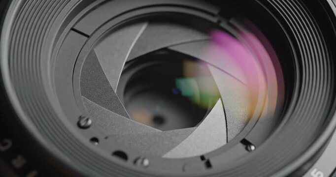 Close-up of a camera lens aperture with colorful reflections, showcasing intricate mechanical design