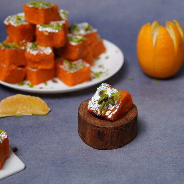 Santra Barfi is a vibrant Indian sweet infused with refreshing orange (santra) flavor. Made using milk solids or khoya blended with sugar and citrus essence, this mithai is known for its bright orange