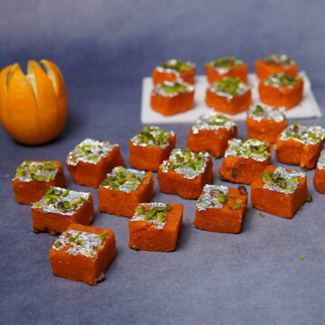 Santra Barfi is a vibrant Indian sweet infused with refreshing orange (santra) flavor. Made using milk solids or khoya blended with sugar and citrus essence, this mithai is known for its bright orange