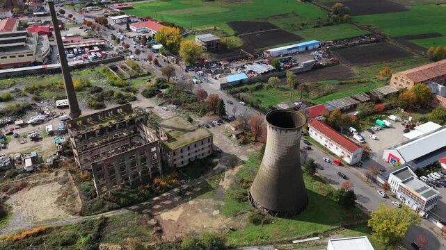 Autumn aerial videoof Kor&ccedil;&euml;&rsquo;s outskirts featuring fields, and the abandoned TEC power station beneath dramatic mountain clouds.