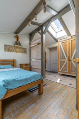 Rustic bedroom interior with wooden beams skylight turquoise bed barn doors