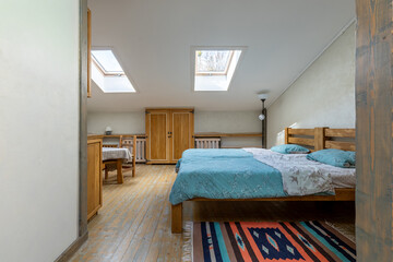Bright rustic attic interior with twin beds and dining area