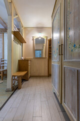 Rustic hallway with hand-painted floral wardrobe and wooden furniture