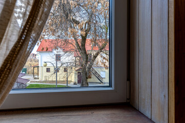 View from the window of a rustic house to a cozy courtyard