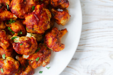 Buffalo Cauliflower in Batter with Celery on a White Plate