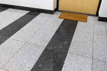Corridor of an apartment building with stone tile flooring; stairwell finishes.