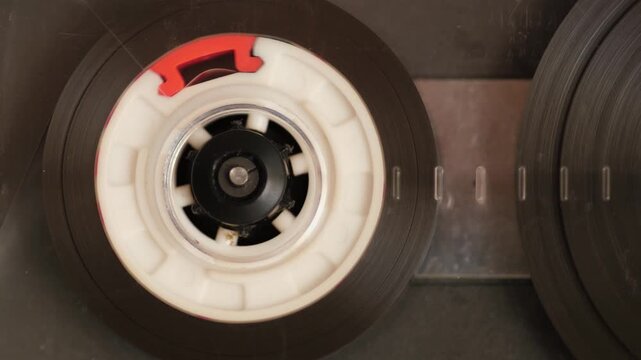 Macro close-up of vintage audio cassette spinning inside cassette player