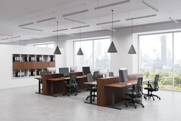 Fototapeta premium Modern office interior with wooden desks and computer workstations near large windows in high-rise building workspace concept. 3D Rendering