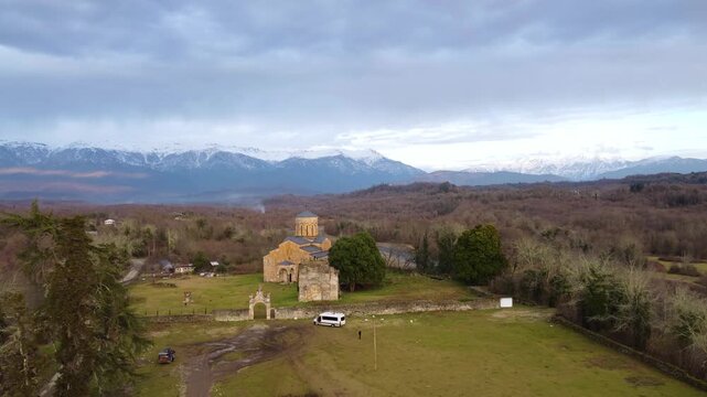 MOKVA, Abkhazia - 4.01.2025: Mokva Cathedral of the Assumption of the Blessed Virgin Mary, aerial view. Christianity. Holy sites. Ancient church built in the 10th century. Christian shrine. Dron. 4К
