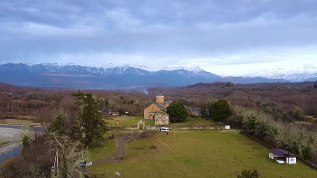 MOKVA, Abkhazia - 4.01.2025: Mokva Cathedral of the Assumption of the Blessed Virgin Mary, aerial view. Christianity. Holy sites. Ancient church built in the 10th century. Christian shrine. Dron. 4К
