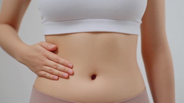ウエストラインに手を当てる女性が体型管理と健康意識を表現
