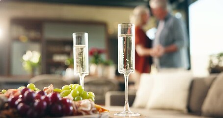 Champagne, glasses and food in home for valentines day, celebration and old people dancing on anniversary. Senior couple, drinks and love with relationship goals, milestone or connection in house