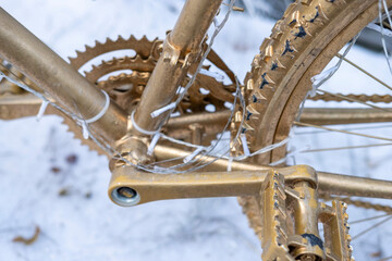 Golden bicycle decorated with lights in the snow. The Concept of Winter Decoration.