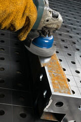 the process of cleaning a metal part from rust using a grinder, side view