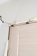 The use of mounting foam by workers to seal cracks and mounting wedges for mounting