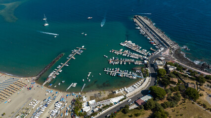 Aerial view of the marina of Giardini Naxos, in the province of Messina, Sicily, Italy. It is a small harbor located on the Mediterranean Sea. There are many small boats anchored there for vacation. © Stefano Tammaro