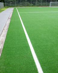Bright green artificial turf field with white line ready for action during a sunny daytime © Ulrich