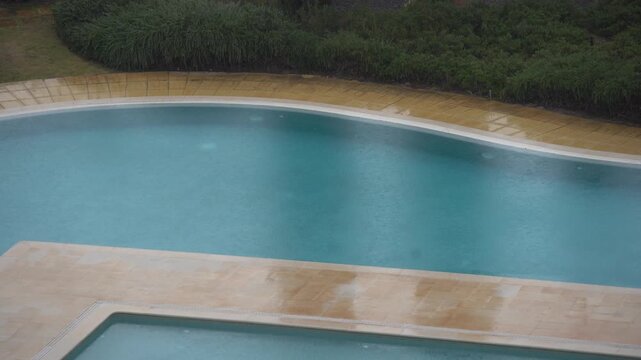 View from window on lounge area near inground swimming pool with deck chairs. Interior design of splendid backyard with large patio for rest