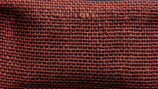Close-up of red woven fabric texture with interlacing fibers
