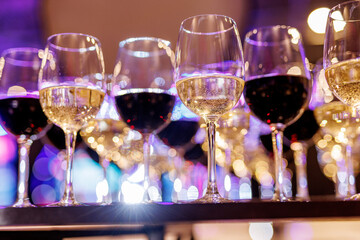 Glasses of red and white wine with bokeh lights