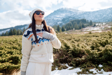 Beautiful woman breathing fresh air in a snowy winter mountain