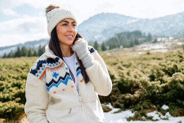 Beautiful  smiling young tourist woman standing in the winter mountain 