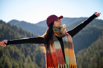 Relaxed woman breathing fresh air in a green pine forest and making breathing exercises 