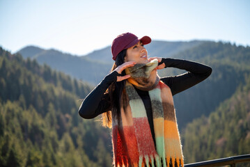 Beautiful  young woman standing  in the autumn mountain with open arms