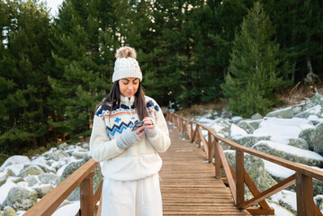 Beautiful  Woman using mobile phone in the Winter Mountain 