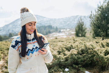 Beautiful  Woman using mobile phone in the Winter Mountain 