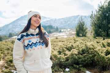 Beautiful  smiling young tourist woman standing in the winter mountain 