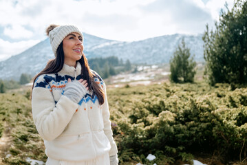 Beautiful woman breathing fresh air in a snowy winter mountain