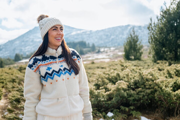 Beautiful  smiling young tourist woman standing in the winter mountain 