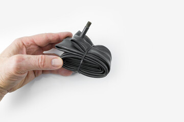 Folded inner bicycle tube in the hand on a white