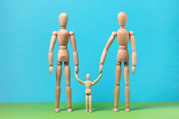 Gestalts or wooden men on a colored background, two adults and one child