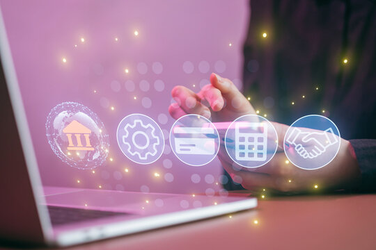 Hands using smartphone with financial icons and laptop on table - Powered by Adobe