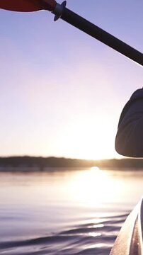 oar paddles on calm water against the background of sunset rays, outdoor activities on a kayak,