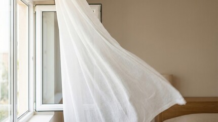 Elegant white curtain flowing in the wind beside an open window  