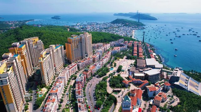 Phu Quoc, Sunset Town, Vietnam. 4k high-quality drone footage, showcasing colorful buildings, blue skies, a watch tower, a kissing bridge, turquoise clear waters, green forest, and golden sand