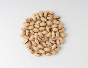 Fried salt pistachio nuts isolated. Baked pistachios pile, roasted green pistache fruit in shell on white