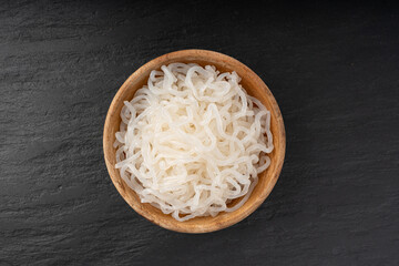 Shirataki or konnyaku pasta in wood bowl. Konjak jelly noodles, Japanese zero calorie sirataki