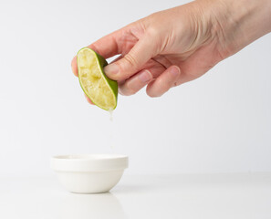 Squeezed lime isolated, squeezed out half green lemon on white background, burnout symbol