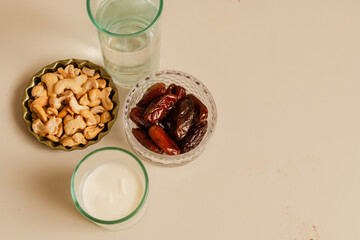 dates, nuts, and chestnuts alongside a glass of water and yogurt